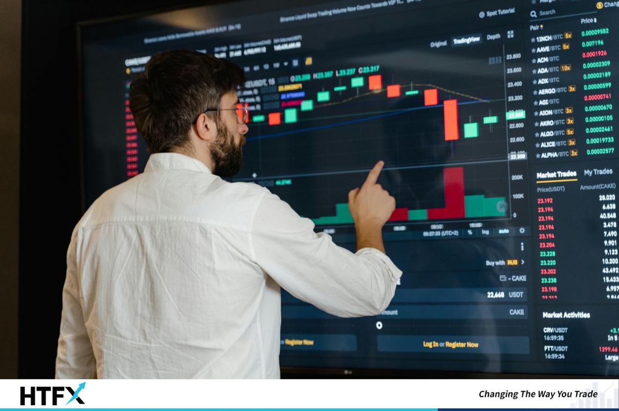 A person pointing at a graph on a large screen
Description automatically generated